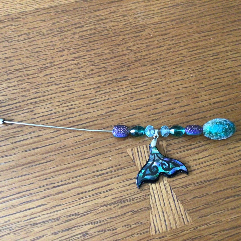 Beaded hat pin with fish tail ornament.